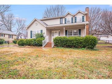 Inviting two-story home with covered porch, lush greenery, and a charming brick stairway at 2515 Winterfield Dr, Gastonia, NC 28056