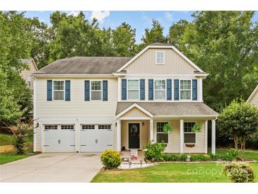 Two-story house with a beige exterior, two-car garage, and landscaping at 7223 Meyer Rd, Fort Mill, SC 29715