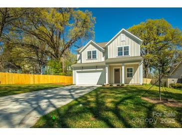 Charming home with a well-manicured lawn, concrete drive and an attached two-car garage at 2630 Rose St, Charlotte, NC 28208
