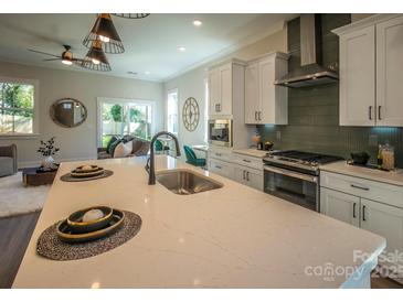 Bright, open kitchen featuring a large island, stainless steel appliances, and modern finishes at 2630 Rose St, Charlotte, NC 28208