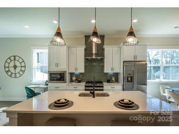 Modern kitchen boasts a large island, stainless steel appliances, and stylish pendant lighting at 2630 Rose St, Charlotte, NC 28208