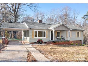 Charming ranch home with gray siding, covered carport, and rocking chairs on the porch at 16 Hill St, York, SC 29745