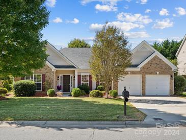 Brick ranch home with 2-car garage and landscaped lawn at 9667 Laurie Nw Ave, Concord, NC 28027