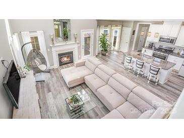 Airy living room features a fireplace, modern furniture, and view into the kitchen at 236 Pinnacle Xing, Shelby, NC 28152