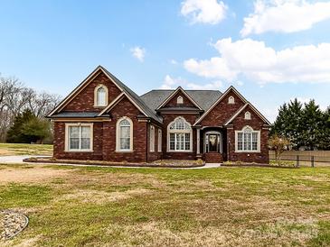 Brick home with landscaped lawn and large windows at 4730 Rollins Pointe Dr, Monroe, NC 28110