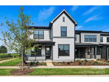 Charming two-story home featuring gray siding, black trim, a covered porch, and landscaped front yard at 97 Seven Oaks Lndg, Belmont, NC 28012