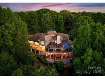 Stunning aerial view of luxury home, surrounded by lush trees and beautiful architectural design at 10310 Wildlife Rd, Charlotte, NC 28278