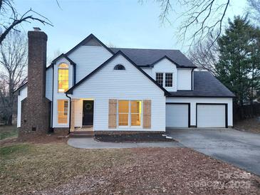 Charming two-story home boasts white siding, black trim, attached garage, and a brick chimney at 513 Mary Charlotte Dr, Charlotte, NC 28262