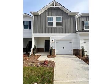 Charming townhome with gray and white facade and attached garage at 1632 Village Grove Ln, Monroe, NC 28110