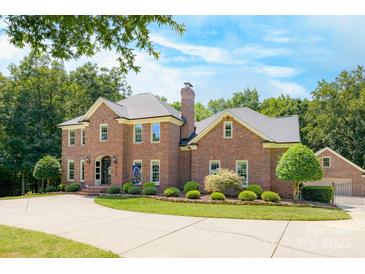 Imposing two-story brick home with a well-manicured lawn and a circular driveway leading to a side-entry garage at 5300 Green Rea Rd, Charlotte, NC 28226
