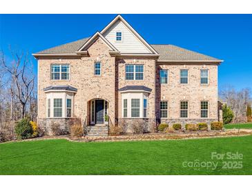 Stately brick home boasts manicured lawn, bay windows, and an inviting arched entryway at 625 Highland Ridge Pt, Clover, SC 29710