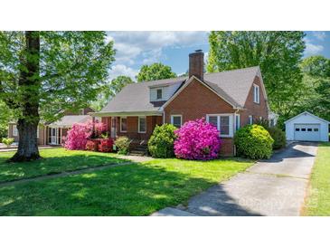 Charming brick home featuring a manicured lawn and vibrant azalea bushes at 112 S 2Nd Ave, Maiden, NC 28650