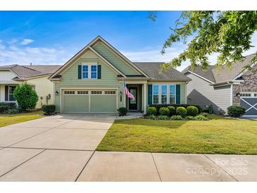 Charming home features a 2-car garage, manicured lawn, and lush landscaping at 8121 Festival Way, Charlotte, NC 28215