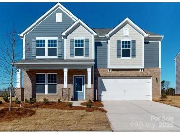 Two-story house with gray and beige siding, a two-car garage, and a front porch at 1805 Augustine St, Monroe, NC 28112