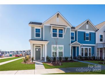 Two-story townhome with light blue siding, and a grassy front yard at 10505 Boudreaux St, Huntersville, NC 28078