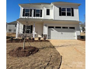 Two-story house with white siding, stone accents, and a two-car garage at 608 Lispenard Ct, Mount Holly, NC 28120