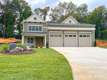 Two-story home with a three car garage, stone accents, and manicured lawn at 139 Poplar Grove Rd, Mooresville, NC 28117