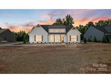 White farmhouse exterior with gray roof, landscaping, and a spacious yard at 2610 Henry Baucom Rd, Monroe, NC 28110