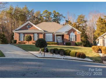 Brick ranch home with landscaped yard and driveway at 7457 Waterleaf Ct, Stanley, NC 28164