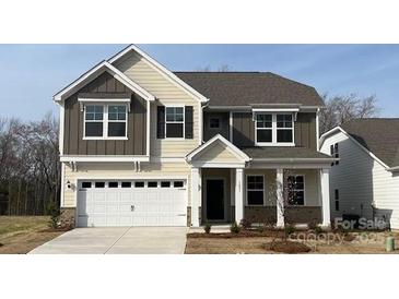 Two-story home with attached garage, neutral siding, and well-manicured front yard at 1051 Bull Dog Ln, Wingate, NC 28174