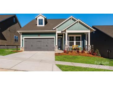 Two-story craftsman style home with gray two-car garage and landscaped front yard at 1010 Lowland Way, Waxhaw, NC 28173