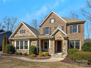 Charming brick and stone home featuring a manicured lawn and inviting front porch at 2257 Tatton Hall Rd, Fort Mill, SC 29715