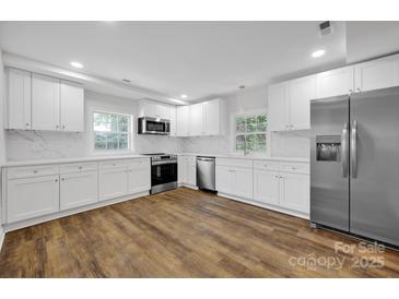 Modern kitchen featuring white cabinets, stainless steel appliances, and quartz countertops at 123 Market Rd, Mooresville, NC 28115