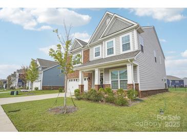 Inviting two-story home boasts a manicured lawn and charming brick and siding facade at 4233 Poplin Grove Dr, Indian Trail, NC 28079