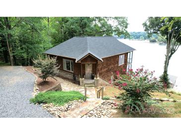 Charming cedar home with stone pathway, mature landscaping, and serene lake views at 152 Bridge Pointe Ln, Hickory, NC 28601