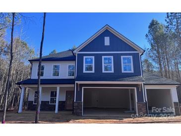 Charming two-story home featuring a two-car garage and a mix of white and blue siding at 1021 Baylor Grv, Monroe, NC 28110