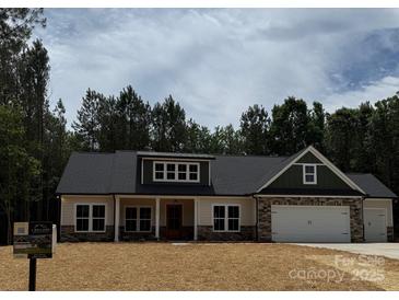Charming single-Gathering home featuring a two-car garage, stone accents, and a well-manicured lawn at 1025 Baylor Grv, Monroe, NC 28112