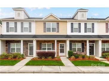 Inviting townhome exterior features a well-maintained lawn and classic architectural details at 4327 Kobuk Ln, Charlotte, NC 28269