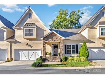 Charming townhome with a stone-accented entryway, white garage doors, and well-maintained landscaping at 5916 Bridger Ct, Charlotte, NC 28211