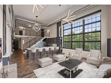 Open living room with modern kitchen and high ceilings at 715 N Graham St # 201, Charlotte, NC 28202