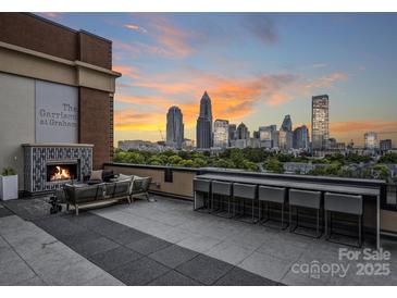 Relaxing rooftop terrace with city views, fireplace, and seating at 715 N Graham St # 201, Charlotte, NC 28202