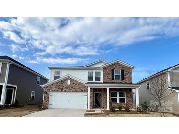 Charming two-story home with brick and white siding, featuring an attached two-car garage and covered front porch at 153 Shepherds Landing Dr, Mooresville, NC 28115