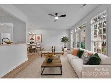 Bright living room with hardwood floors, fireplace, and access to kitchen at 5346 Johnston Mill Ct, Charlotte, NC 28269