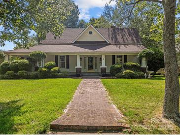Charming home featuring a brick walkway, manicured lawn, and a welcoming front porch at 405 7Th St, Spencer, NC 28159