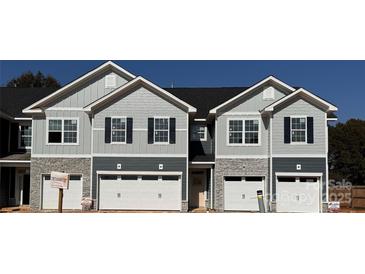 New construction townhome exterior with gray siding, stone accents, and white garage doors at 4069 Port Richmond Ave # 16, Gastonia, NC 28056