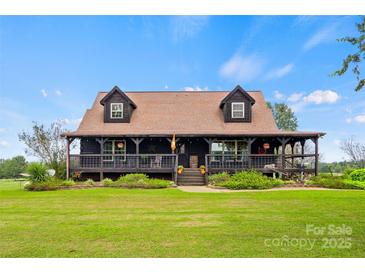 Charming log cabin home with a wraparound porch and landscaped yard at 4796 Dewitt Rd, Blackstock, SC 29014