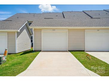 Exterior view of a townhouse with a two-car garage and a concrete driveway and well-maintained lawn at 939 Cobbled Way, Fort Mill, SC 29715