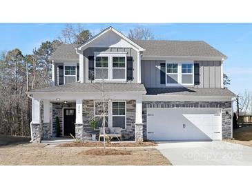 Two-story house with gray siding, stone accents, and a two-car garage at 2040 White Cypress Ct # Kh09, Charlotte, NC 28216