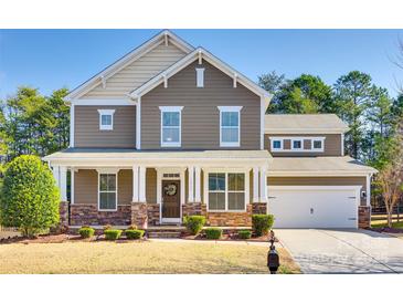 Charming two-story home with a covered porch, stone accents, and a well-manicured front yard at 16840 Rudence Ct, Charlotte, NC 28278