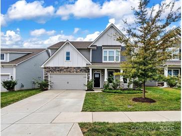 Two-story house with gray siding, stone accents, and a front porch at 145 Yellow Birch Loop, Mooresville, NC 28117