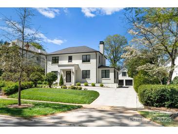 Stunning two-story home with white brick exterior, landscaping, and driveway at 1446 Queens W Rd, Charlotte, NC 28207