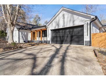 White brick ranch house with black garage door and wood accents at 3305 Cameo Trl, Gastonia, NC 28056