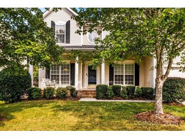 Two-story house with a front porch, mature trees, and well-manicured lawn at 9826 Edinburgh Ln # 282, Charlotte, NC 28269