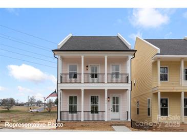 Charming two-story home with a welcoming front porch and second-story balcony, featuring black railings and white pillars at 5850 Pittmon Ln, Kannapolis, NC 28081