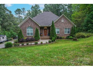 Charming single-story brick home featuring manicured landscaping and a well-maintained lawn at 10604 Russet Pl, Charlotte, NC 28227