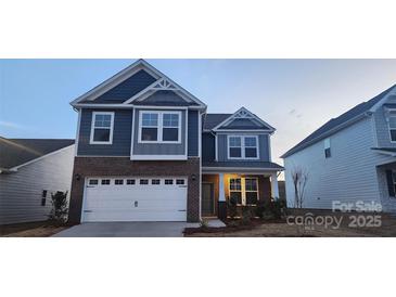 Beautiful two-story home boasts a mix of brick and siding, attached garage, and classic architectural details at 136 Ella Claire Dr, York, SC 29745